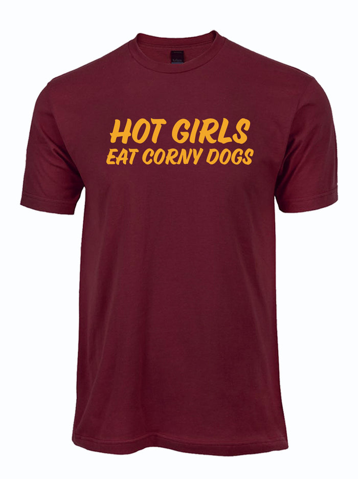 A maroon short-sleeve crewneck t-shirt with the phrase 'HOT GIRLS EAT CORNY DOGS' printed across the chest in a bold yellow font, shown against a plain white background.
